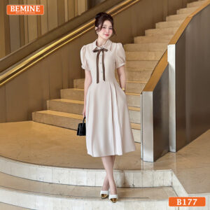 Người mẫu mặc đầm thiết kế BEMINE B177 dáng chữ A, cổ sơ mi nơ, phong cách chuyên nghiệp.