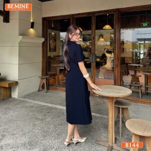 Đầm BEMINE B144, kiểu dáng cổ sen và tùng xếp ly, với điểm nhấn đính đá làm nổi bật khuôn mặt.