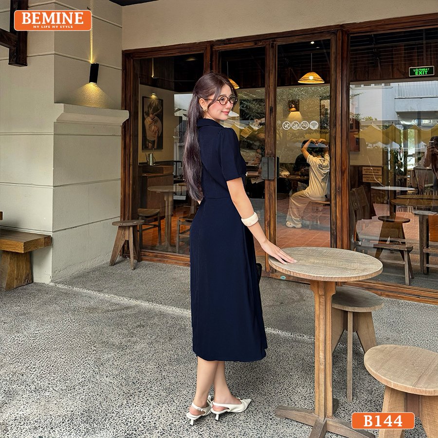 Đầm BEMINE B144, kiểu dáng cổ sen và tùng xếp ly, với điểm nhấn đính đá làm nổi bật khuôn mặt.