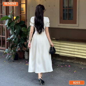 Chi tiết cổ vuông giúp tôn xương quai xanh và điểm nhấn hoa đính điệu đà trên đầm BEMINE B203.