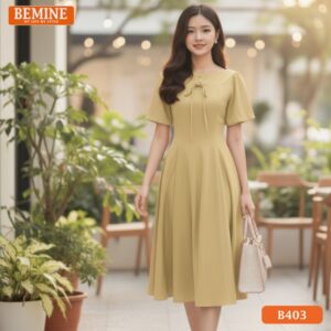 Mẫu đầm công sở BEMINE B403 dáng chữ A, nổi bật với thiết kế cổ thuyền thanh lịch, màu vàng rực rỡ.