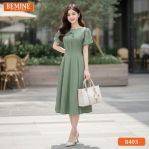 Người mẫu mặc đầm thiết kế BEMINE B403 dáng chữ A, cổ thuyền, màu xanh, phong cách chuyên nghiệp.